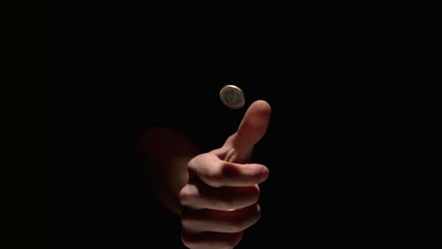 Hand flipping a euro coin in slow motion